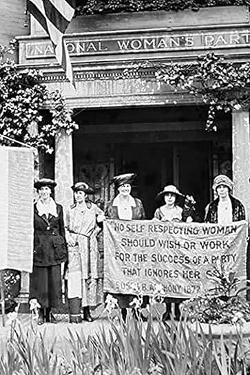 Suffragettes protest with banner in front of building